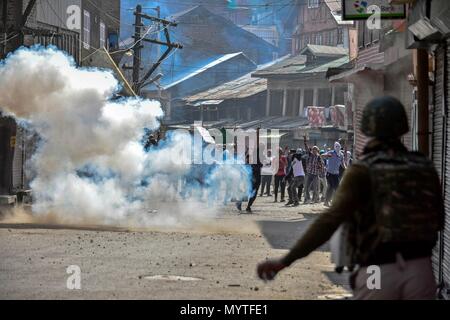 June 8, 2018 - Srinagar, J&K, India - A tear gas shell fired by Indian policeman explodes near the Kashmiri protesters during clashes after the Friday congregational prayers in Srinagar, Indian administered Kashmir.Thousands of people across the Kashmir valley observed last Friday of Ramadan ( AL-Quds Day) in solidarity with oppressed Palestinians during which rallies, protest demonstrations were taken out while youth clash with government forces after Friday prayers in old city of Srinagar. The protesters were chanting anti-India and pro-freedom slogans. Forces fired tear gas canisters and p Stock Photo
