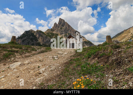 Small white chapel with Sass de Stria mountain on top of Falzarego pass in the Dolomites, Italy Stock Photo