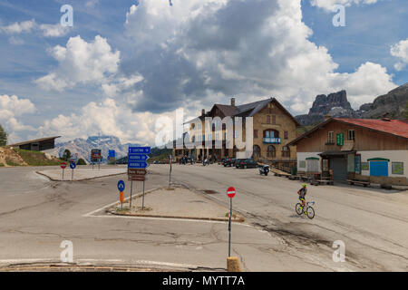 Falzarego Pass, Italy - May 31, 2017: On top of Falzarego Pass road in the Dolomites at elevation 2117 m with a cyclist crossing Stock Photo