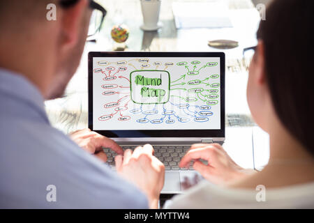 Close-up Of Two Businesspeople Making Mind Map On Laptop Stock Photo