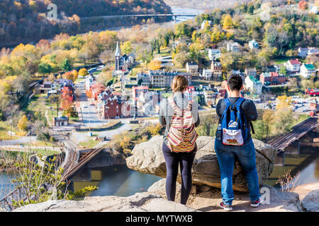 Harper's Ferry, USA - November 11, 2017: Hiker people women couple at overlook with colorful orange yellow foliage fall autumn forest with small villa Stock Photo
