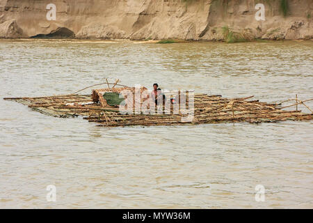 Local men floating on a bamboo raft down Ayeyarwady river near Mandalay, Myanmar. Ayeyarwady river is the largest river in Myanmar.