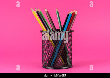 Various of colored pencils in metal basket isolated on pink background. Art and Education concept Stock Photo
