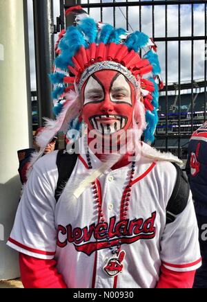 Eagle Ave, Cleveland, Ohio, USA. 25th Oct, 2016. Dressed in feathers and a painted, a fan of the Cleveland Indians waits outside Progressive Field before the start of game 1 of the World Series on October 25, 2016. Credit:  gadgetphoto/StockimoNews/Alamy Live News Stock Photo