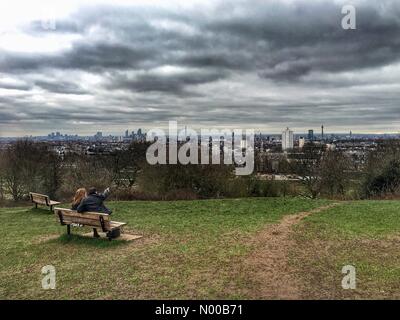 Hemmingway Cl, London, UK. 21st Feb, 2017. UK Weather: A young couple take in the view of the London skyline from Parliament Hill, on an overcast and cloudy day. Credit: Jamie Gladden/StockimoNews/Alamy Live News Stock Photo