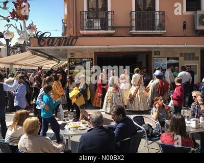 20, Dénia, Alicante, Spain. 18th Mar, 2017. Fallas in Denia, Spain. Ladies dressed in traditional costumes stand outside a bar as tourists walk past. The festival is very popular and continues all weekend. Credit: Scott Ramsey/StockimoNews/Alamy Live News Stock Photo