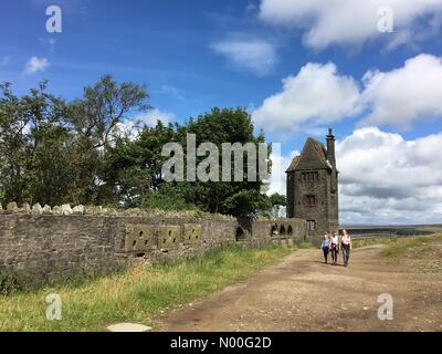 UK Weather: Sunny morning in Rivington. Family walking by the Pigeon Tower folly in Rivington near Chorley in Lancashire Stock Photo