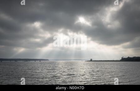 Sunlight bursts through clouds over Poole Harbour in Dorset on a calm day before hurricane Ophelia sweeps across the UK Credit: Dan Tucker/StockimoNews/Alamy Live News Stock Photo