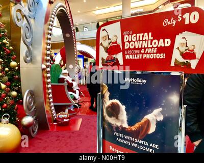 Garden City, New York, USA. 12th Nov, 2017. Santa Claus sits in big sleigh ready for children to visit at Christmas Tree scene, at Roosevelt Field shopping mall, Long Island. Signs have info for buying digital download photos with Santa. Credit: aparry/StockimoNews/Alamy Live News Stock Photo