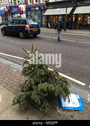London, UK. 8th January, 2018. London, UK. 8th Jan, 2018. A discarded Christmas tree on Muswell Hill Broadway in London 2 days after the epiphany on January 8 2018 Credit: Louisa Cook/StockimoNews/Alamy Live News Credit: Louisa Cook/StockimoNews/Alamy Live News Stock Photo