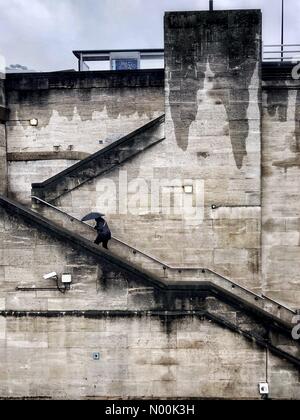 London, UK. 24th Jan, 2018. UK Weather: A woman holding an umbrella walks up the stone staircase on Waterloo Bridge, on a gloomy, rainy winter afternoon in London, England, UK. Credit: Jamie Gladden/StockimoNews/Alamy Live News Stock Photo