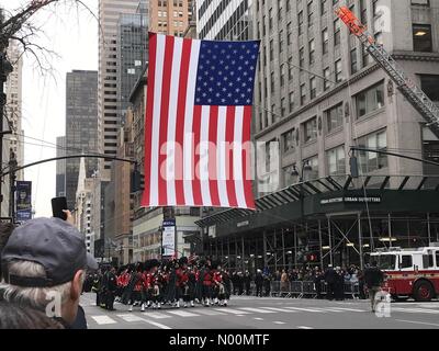 New York City, USA. 27th Mar, 2018. End of NYFD Lt. Michael David's on funeral procession leaving St Patricks Cathedral in New York City. A giant AMERICAN Flag hangs from Two NYFD ladder tracks at 5th Avenue at 43rd Street. Credit: ses7/StockimoNews/Alamy Live News Stock Photo