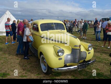 Lancashire, UK. 18th August 2018. Visitors examine a classic American Chrysler car at the Lytham Wartime 1940's Nostalgia Weekend Credit: Roger Goodwin/StockimoNews/Alamy Live News Stock Photo