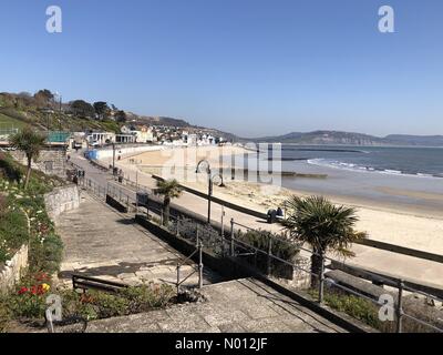 Lyme Regis, Dorset, UK. 25th March, 2020. UK Weather: The beach at Lyme Regis is deserted on a warm sunny day on the second day of the Government's Corvid-19 octal distancing measures. Credit: Celia McMahon/StockimoNews/Alamy Live News Stock Photo
