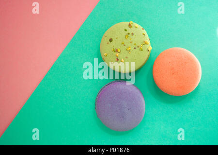 Three delicious french dessert macarons on multicolored background with text space. Stock Photo