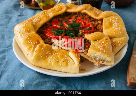 Saudi aysh abu laham or Saudi pizza or meat galette, traditional arabic and middle eastern food concept. Stock Photo