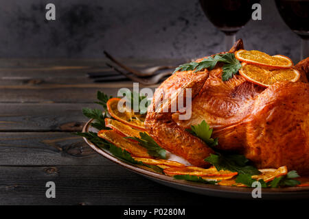 Homemade roasted whole chicken with parsley and oranges, selective focus. Stock Photo