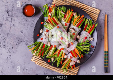 Spring rolls with vegetables and shiitake mushrooms on a plate, top view. Stock Photo