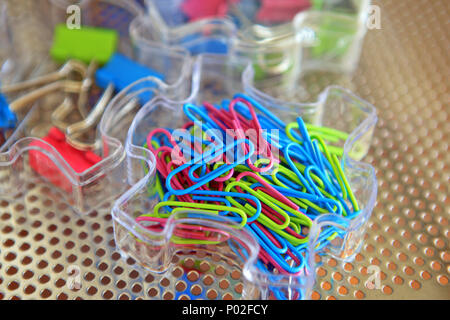 Colourful paper clips and bulldog clips in plastic trays in a home office Stock Photo