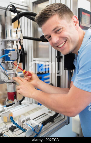 Portrait Of Male Engineer Working On Machine In Factory Stock Photo