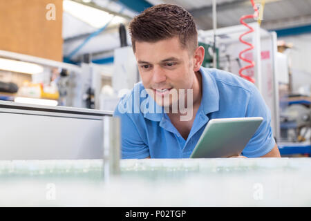 Male Engineer With Digital Tablet Working In Bottle Capping Factory Stock Photo