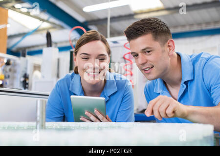 Engineer And Apprentice With Digital Tablet Working In Bottle Capping Factory Stock Photo