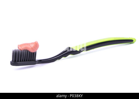 Toothbrush black and green with toothpaste on a white background Stock Photo