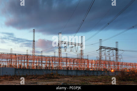 electricity transmission pylon silhouetted against blue sky at dusk Stock Photo