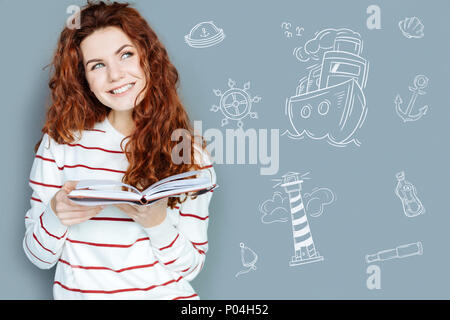 Happy young woman smiling and enjoying a new book Stock Photo