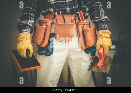 Construction Contractor on Duty Concept Photo. Worker with Large Tools Belt and Some Tools in Hands. Stock Photo
