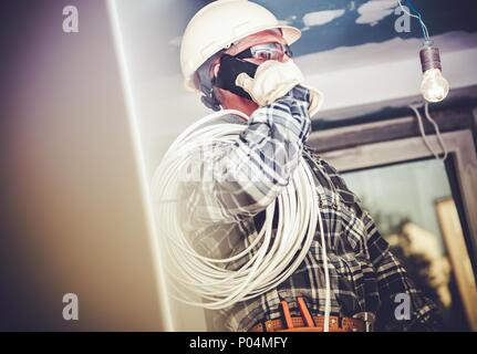 Electric Contractor Job. Professional Electrician Making Phone Conversation with Investor. Stock Photo