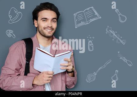 Dreamy man reading fantasy books and dreaming about witches and wizards Stock Photo