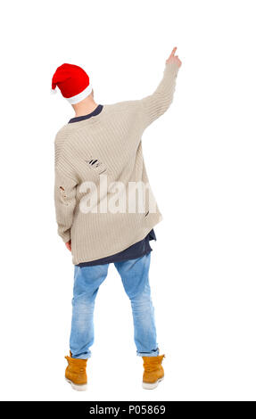 Back view of a man in a Santa Claus hat pointing upwards. Rear view people collection.  backside view of person.  Isolated over white background. Guy  Stock Photo