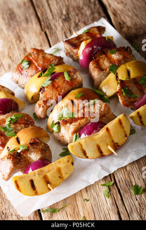 Grilled pork kebabs with fresh apples and red onions on skewers close ...