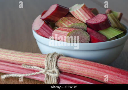 Close-up of slised rhubarb in a bowl on wooden background Stock Photo
