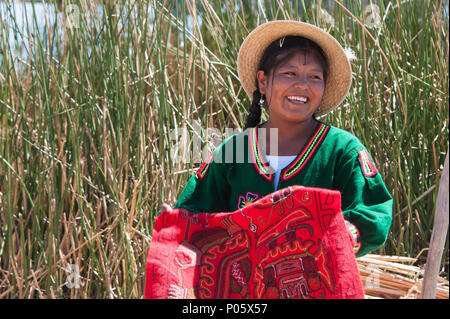 Local residents welcome tourist visiters to Uros, the floating Islands in Peru Stock Photo