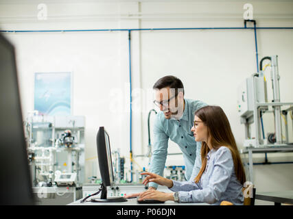 Side view of focused students using desktop pc in classroom at Technical faculty Stock Photo