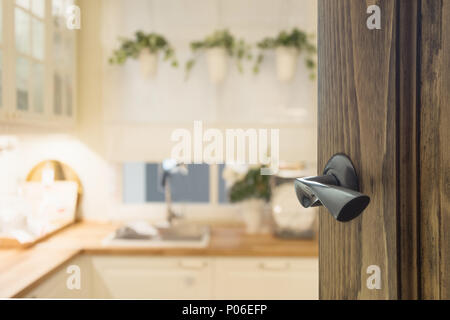 Opened wooden door to modern kitchen interior for background. Stock Photo