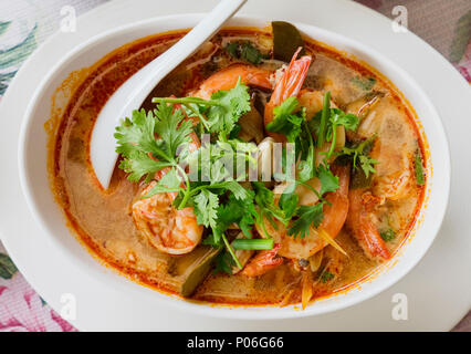 Tom yam kung, the traditional Thai sour soup with prawns and champignons, topped with coriander. The photo shows the red version of the soup, made wit Stock Photo