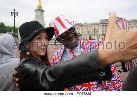 London, UK, 9 June 2018. The annual Trooping the Colour has taken place in London in honour of Queen Elizabeth's birthday. Thousands lined the streets to welcome Her Majesty and other members of the Royal Family as they travelled by coach from Buckingham Palace to Horse Guards Parade. Here there's time for a selfie before the parade for Joseph Afrane and a visitor to England. Credit: Clearpix/Alamy Live News Stock Photo