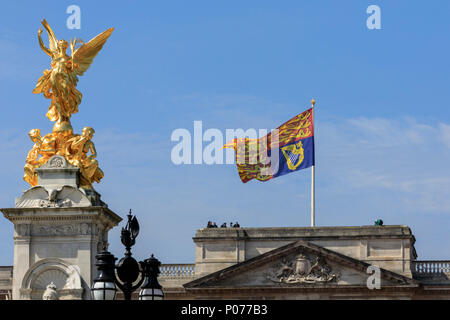 The Mall, London, UK, 9th June 2018. The Royal Standard flies up on Buckingham Palace. The Sovereign's birthday is officially celebrated by the ceremony of Trooping the Colour, the Queen's Birthday Parade. Troops from the  Household Division, overall 1400 officers and soldiers are on parade, together with two hundred horses; over four hundred musicians from ten bands and corps of drums. The parade route extends from Buckingham Palace along The Mall to Horse Guards Parade, Whitehall and back again. Stock Photo