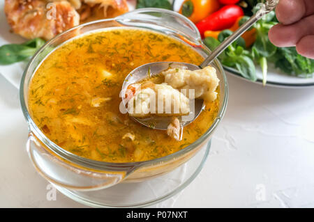 Soup with dumplings and meat on a wooden table, a portion of Bavarian soup griesnockerl, selective focus. Close up. Stock Photo