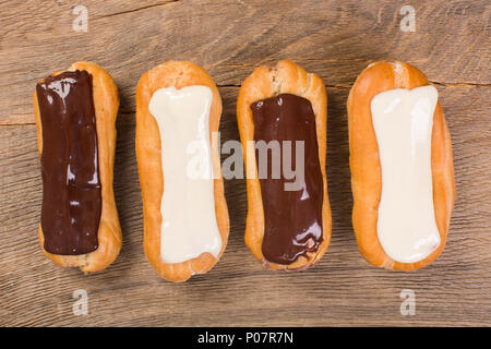 Eclairs different species on wood background isolated.  Stock Photo