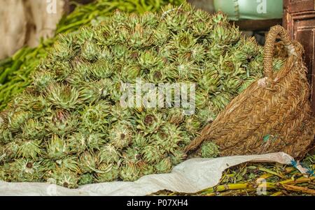 Big bunch of small baby artichokes on display on a market stall in Morocco Stock Photo