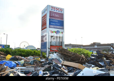 Fly tipping rubbish is left in front of the shop signs including Tesco Direct and The Toys R Us both now closed stores, on the North Circular, near th Stock Photo