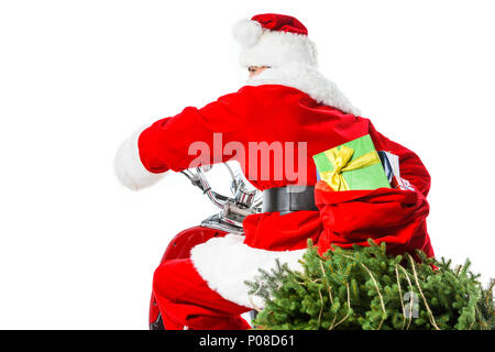 Santa Claus riding red scooter with christmas tree and big bag full of presents, isolated on white Stock Photo