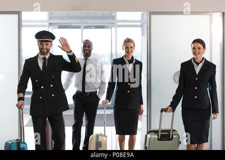 young aviation personnel team with suitcases at airport after flight Stock Photo