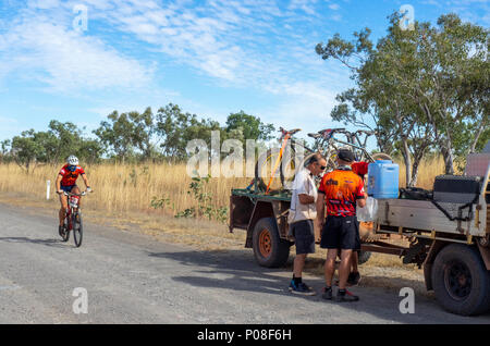 A Gibb Challenge 2018 cyclist riding past a support vehicle and trailer on the dirt Gibb River Road Kimberley WA Australia. Stock Photo