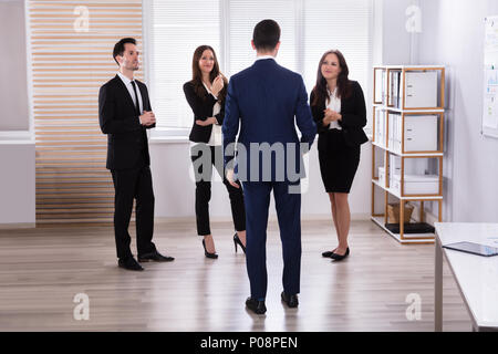 Manager With His Young Colleague Having Discussion At Workplace Stock Photo