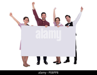 Excited Young Male And Female Staff Holding Billboard Raising Their Arms On White Background Stock Photo